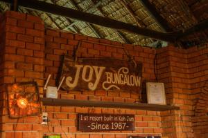 Una pared de ladrillo con un cartel que lee el reino de los juguetes en JOY Bungalow Resort and Restaurant, en Ko Jum