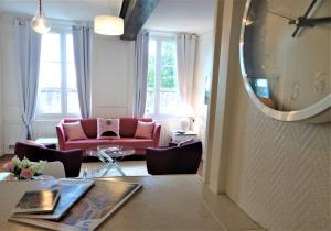 sala de estar con sofá rojo y espejo en Le Cardinal en Chartres