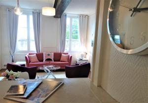 a living room with a red couch and a mirror at Le Cardinal in Chartres