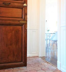 Una gran puerta de madera en una habitación con una mesa. en Le Cardinal en Chartres