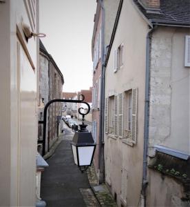 un callejón con una luz en el lateral de un edificio en Le Cardinal en Chartres