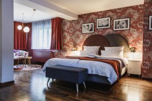 a bedroom with a large bed with red wallpaper at The Circus Hotel in Berlin