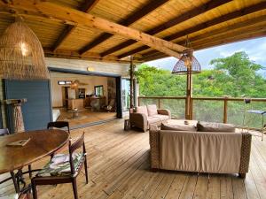 a living room with a couch and a table on a deck at Lodge Nature in Saint-Leu