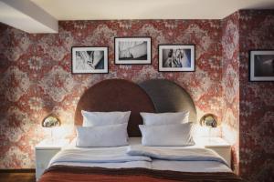 um quarto com uma cama grande com três fotografias na parede em The Circus Hotel em Berlim