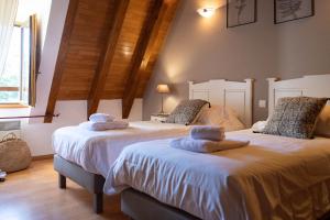 dwa łóżka siedzące obok siebie w pokoju w obiekcie Villa en pierre 4 pers avec Piscine w mieście Coly