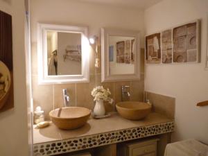 ein Badezimmer mit zwei Waschbecken und zwei Spiegeln in der Unterkunft SALSA in Ceyreste