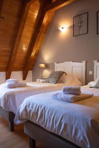 2 łóżka w pokoju z drewnianym sufitem w obiekcie Villa en pierre 4 pers avec Piscine w mieście Coly