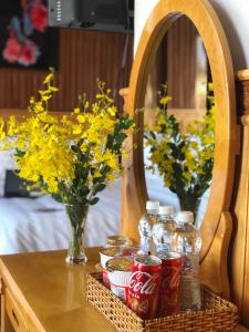 a table with cocacola bottles and flowers and a mirror at KHÁNH AN HOTEL in Da Lat