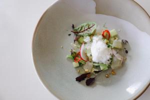 a white plate with a salad on a table at Housel Bay Hotel in Lizard