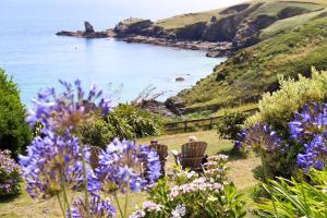 a garden with purple flowers and a body of water at Housel Bay Hotel in Lizard