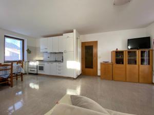 a large living room with white cabinets and a television at Casetta Turati in Castelfondo