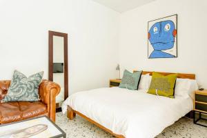 1 dormitorio con 1 cama y 1 sofá en Orchard Lane en Ciudad del Cabo