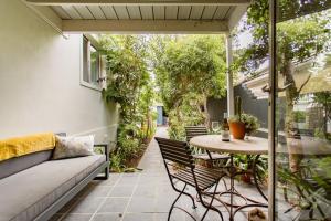 een patio met een bank en een tafel bij Orchard Lane in Kaapstad