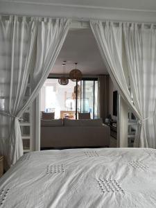 a bedroom with a white bed and a couch at Éden Marin : Duplex Prestige in Bouznika