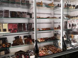 uma padaria cheia de diferentes tipos de alimentos em El Indio CHocolatería Boutique Hostel em Pinto