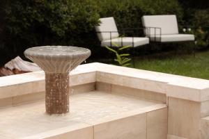 a bird bath in the middle of a bench with two chairs at Heura Petit Hotel in Ciudad Lujan de Cuyo