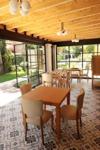 uma sala de jantar com mesas, cadeiras e janelas em Heura Petit Hotel em Ciudad Lujan de Cuyo