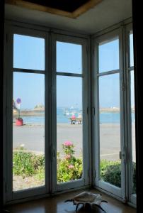 una ventana con vistas a la playa desde una casa en Maison de pêcheur Loguivy de la mer en Ploubazlanec