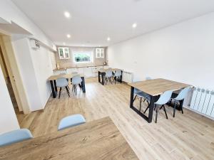 a room with tables and chairs and a kitchen at Noclegi Kielce - Dom nad rzeką in Kielce