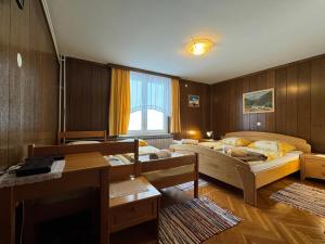 a room with two beds and a living room with a table at Pension Cerkovnik in Bohinj