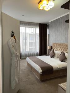 a bedroom with a bed with a robe on the wall at Hotel FN Shymkent in Shymkent