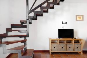 een woonkamer met een tv en een trap bij Finca Emblemática - Nº2 Chibusque in La Vegueta