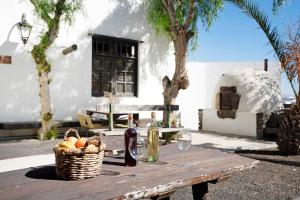 een picknicktafel met een mand met fruit- en wijnflessen bij Finca Emblemática - Nº2 Chibusque in La Vegueta