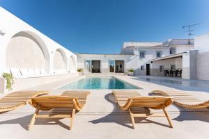 een zwembad met ligstoelen en een zwembad bij MalagaSuite Villa Nomada El Torcal in Antequera