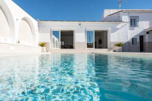 a swimming pool in front of a white house at MalagaSuite Villa Nomada El Torcal in Antequera