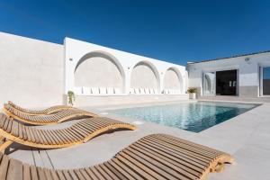 a pool with two lounge chairs next to a building at MalagaSuite Villa Nomada El Torcal in Antequera +40 photos