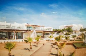 a house on the beach with palm trees in front of it at Двухкомнатные апартаменты в жилом комплексе Caesar Beach D2 Flat11 in Boğaz