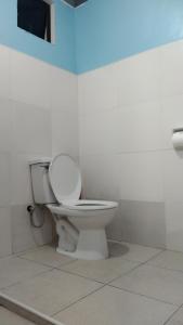uma casa de banho com um WC branco num quarto em ELEN INN - Malapascua Island - Private Fan room with shared bathroom #5 em Malapascua