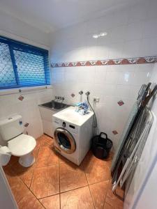 a bathroom with a toilet and a washing machine at Relaxation Holiday Home in Bellerive in Bellerive