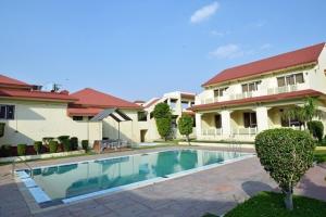a swimming pool in front of a house at Shiva Oasis Resort in Neemrana