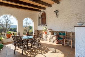 patio con mesa, sillas, mesa y algunas ventanas en Masia Mas Bolet, en Palafolls