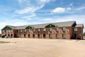 an empty parking lot in front of a large brick building at Super 8 by Wyndham Salina I-70 in Salina