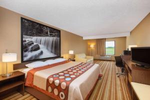 a hotel room with a large bed and a flat screen tv at Super 8 by Wyndham Salina I-70 in Salina +39 photos
