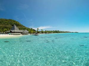a beach with a resort in the middle of the water at Sofitel Kia Ora Moorea Beach Resort in Maharepa