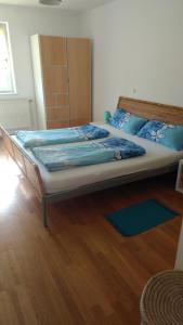 a large bed in a room with a wooden floor at Rooming Green Weyregg in Weyregg