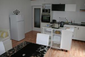 a kitchen with white cabinets and a white refrigerator at Rooming Green Weyregg in Weyregg