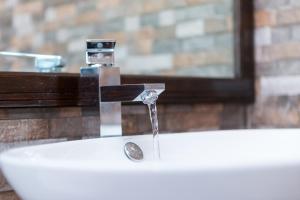 ein Waschbecken im Badezimmer mit einem Wasserhahn, aus dem Wasser kommt in der Unterkunft Beach Cottages in Bel Ombre + 78 Fotos