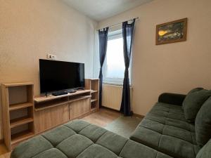 a living room with a couch and a flat screen tv at Pension Cerkovnik in Bohinj
