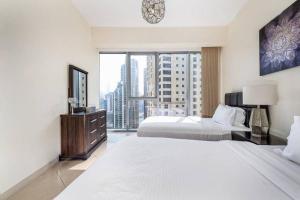a hotel room with two beds and a large window at Trident Grand Residence,Dubai Marina - 3BR Apartment - Allsopp&Allsopp in Dubai