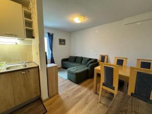 a kitchen and a living room with a couch and a table at Pension Cerkovnik in Bohinj