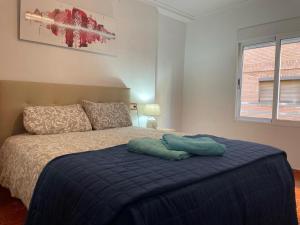 ein Schlafzimmer mit einem Bett mit einer blauen Decke in der Unterkunft Germanies Home, Algemesi Home in Algemesí