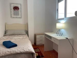 een slaapkamer met een bed, een bureau en een raam bij Germanies Home, Algemesi Home in Algemesí