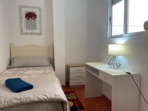 une chambre avec un lit, un bureau et une fenêtre dans l'établissement GERMANIES HOME y Garaje , Algemesí Home, à Algemesí