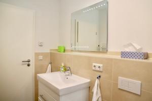 a bathroom with a sink and a mirror at Haus Sonne Ferienwohnung 5 in Thiessow +19 photos