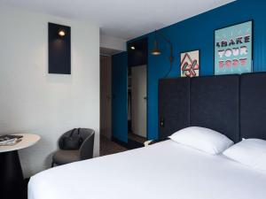 a hotel room with a bed and a chair at ibis Paris Italie Tolbiac in Paris