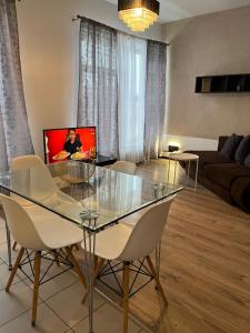 een woonkamer met een glazen tafel en stoelen bij Near Station Apartment in Vilnius